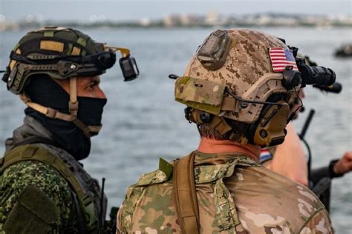 What do Navy SEALs carry into combat?