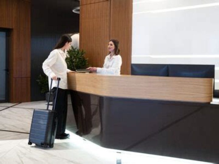 What does a front desk clerk do at a hotel?