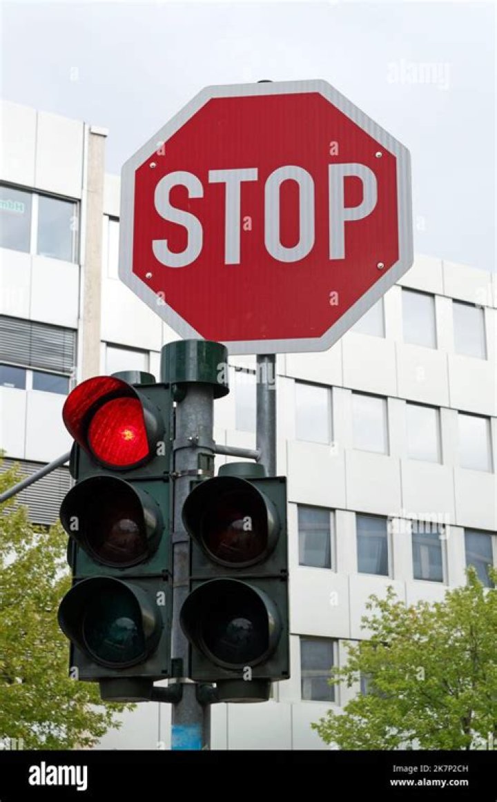 Where do you need to stop at a red traffic light?